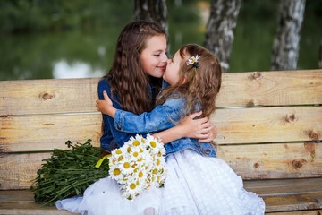 Cute smiling sisters having fun outside in summer. Happy family and friendship concept 