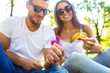 © maxbelchenko - Young girl and boy playing with a fidget spinners in the park. stress relieving toy. Sunny summer day. They laugh and smile. Great mood.