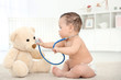 © Africa Studio - Cute little baby with stethoscope and toy bear playing at home. Health care concept