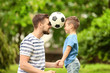 © Africa Studio - Dad and son with soccer ball in green park
