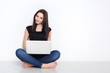 © Prostock-studio - Woman using laptop sitting on the studio floor