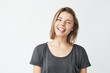 © Cookie Studio - Funny cute young girl smiling winking showing tongue looking at camera over white background.