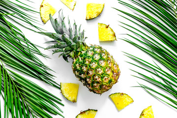  Pineapple and palm branch on white background top view