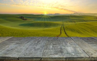 Wall Mural - wood board table in front of field of wheat on sunset light. Ready for product display montages