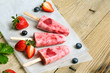 Fresh homemade strawberry ice cream on wooden background. Organic and vegan popsicles