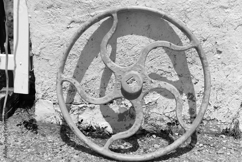 Fotografie, Obraz Big metal crane wheel standing next to a building