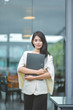 © Suntipong - Young pretty business woman with laptop in the office, smiling pretty young business woman in glasses sitting on workplace. Selective focus
