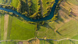 River bend surrounded by fields from bird's eye view.