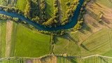 Fototapeta Sawanna - River bend surrounded by fields from bird's eye view.