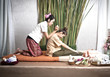 Thai Masseuse doing massage for woman in spa salon. Asian beautiful woman getting thai herbal massage compress massage in spa.She is very relaxed.  Healthy Concept.
