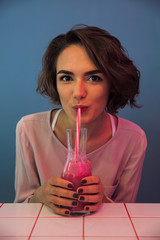 Wall Mural - Close up of a pretty young girl drinking smoothie