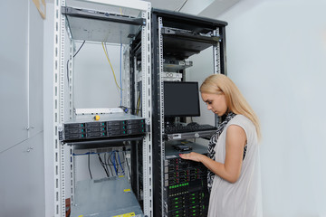 Young woman engineer It technician in the data center server room.