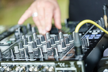 Dj works on mix console at outdoor party