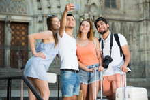 Four Young Travellers Smiling And Making Selfie