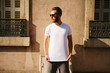 Hipster handsome male model with beard  wearing white blank  t-shirt with space for your logo or design in casual urban style