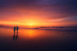 © mimadeo - couple walking on beach at sunset