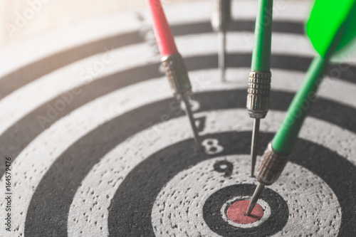 Fotografía dart arrow hitting in the target center of dartboard,abstract of success