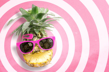 Wall Mural - Pineapple wearing sunglasses on circle pattern pink and white background with copy space and pastel tone. In summer holiday.