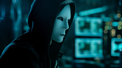 Aufkleber - Masked Hacktivist Organizes malware Virus Attack on Global Scale. Hacker in Underground Secret Location Surrounded by Displays and Cables.