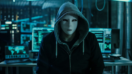 Aufkleber - Dangerous Internationally Wanted Hacker with Covered Face Looking into the Camera. In the Background His Operating Room with Multiple Displays and Cables.