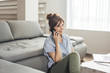 © LUMINA IMAGES - Pretty ginger Caucasian woman sitting on the floor at home and talking on cell phone and smiling.