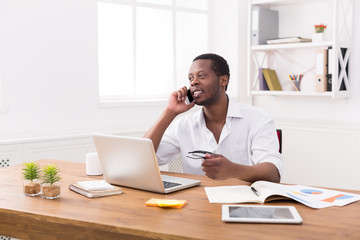 Wall Mural - Young black businessman call mobile phone in modern white office