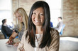 © Amber Antozak - Asian professional woman smiling with creative office group