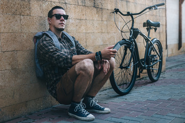 Poster - Young Traveler Man Sitting With Fixed Gear Bicycle in The Street Daily Routine Lifestyle