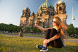 Pretty gil sitting in front of Berlin Cathedral doing selfie