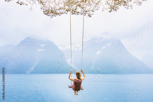 Fotografía dream concept, beautiful young woman on the swing in fjord Norway, inspiring lan