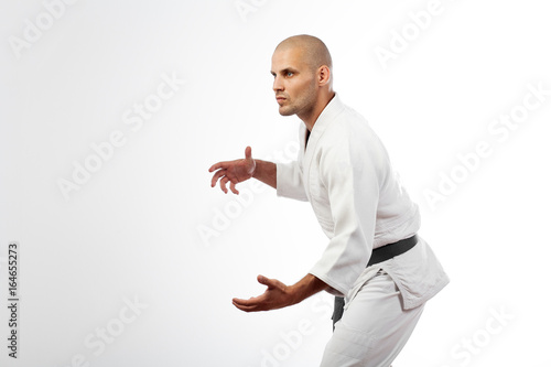 Fotografie, Obraz Young sporty man in white kimono for sambo, judo, jujitsu posing on white backgr