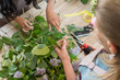 © LIGHTFIELD STUDIOS - cropped shot of young florists arranging beautiful flowers and green leaves in flower shop
