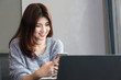 © ChayTee - Portrait of happy asian young woman smiling and working with laptop in coffee shop café.