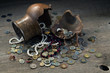 A chopped clay pot, jewels and a pile of coins