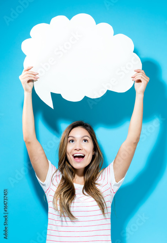 Young woman holding a speech bubble on a blue background Wallpaper Mural