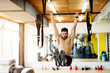 © Dusan Petkovic - Fitness man hanging on horizontal bar performing legs raises, in the gym.