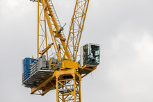 Closeup On Building Construction Tower Crane Yellow Cabin With Operator