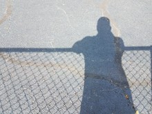 Shadow Of Man With Shadow Of Fence