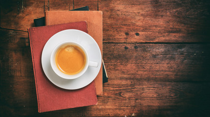 Wall Mural - Vintage books and a cup of coffee on wooden background