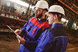 © Evgeniy Kalinovskiy - Engineer-constructor and worker discuss the construction project against the background of an industrial plant
