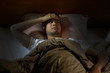 © amenic181 - Depressed man suffering from insomnia lying in bed