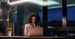 © .shock - black businesswoman using a laptop in night startup office