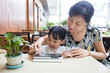Leinwandbild Motiv Asian Chinese little girl playing tablet computer with her mother