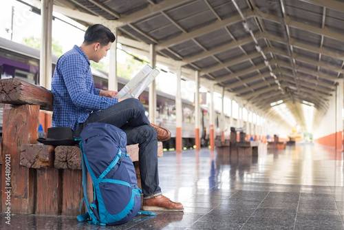 Zdjęcie XXL człowiek podróżujący z plecakiem szukać mapę lokalizacji na stacji pociągu