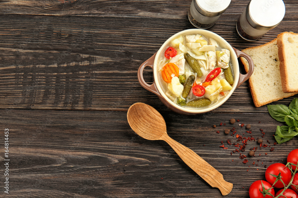 Tureen with turkey soup on wooden table