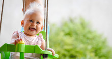 Happy Cheerful Baby Smiling While On Swing