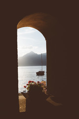 Shooting through a window sill towards sunset and boat at Lake Como, Italy