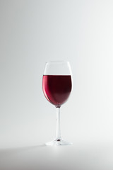 Wall Mural - close-up view of wineglass full of red wine isolated on white