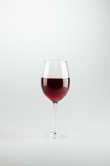 Wall Mural - close-up view of wineglass full of red wine isolated on white