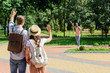 © LIGHTFIELD STUDIOS - back view of couple waving to african american man in park